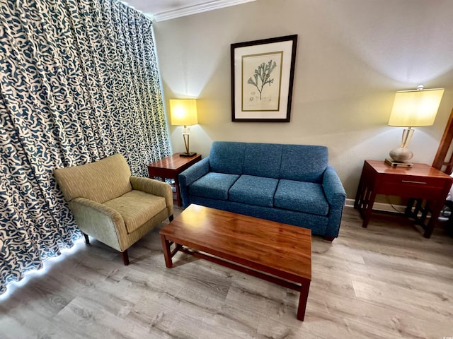 sitting room with hardwood / wood-style flooring and crown molding