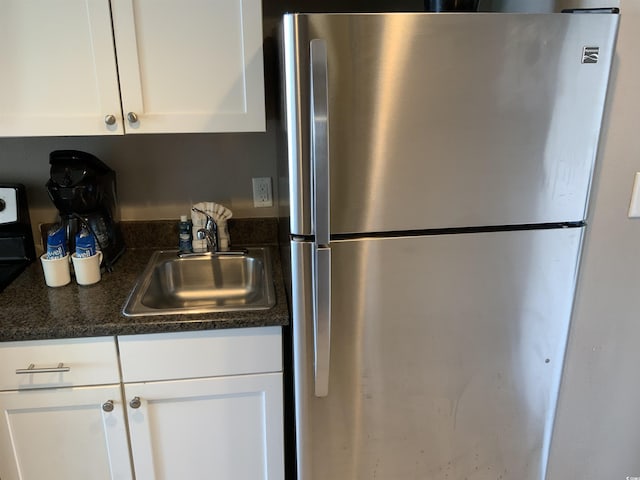 6900 N Ocean Blvd Unit 614, Myrtle Beach, SC 29572 - kitchen with freestanding refrigerator, a sink, and white cabinets