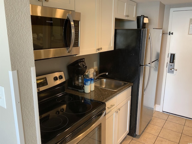 6900 N Ocean Blvd Unit 614, Myrtle Beach, SC 29572 - kitchen with appliances with stainless steel finishes, white cabinets, a sink, and light tile patterned floors