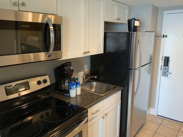 6900 N Ocean Blvd Unit 614, Myrtle Beach, SC 29572 - kitchen with appliances with stainless steel finishes, light tile patterned flooring, a sink, and white cabinetry