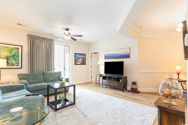 living room featuring crown molding, ceiling fan, and light hardwood / wood-style flooring