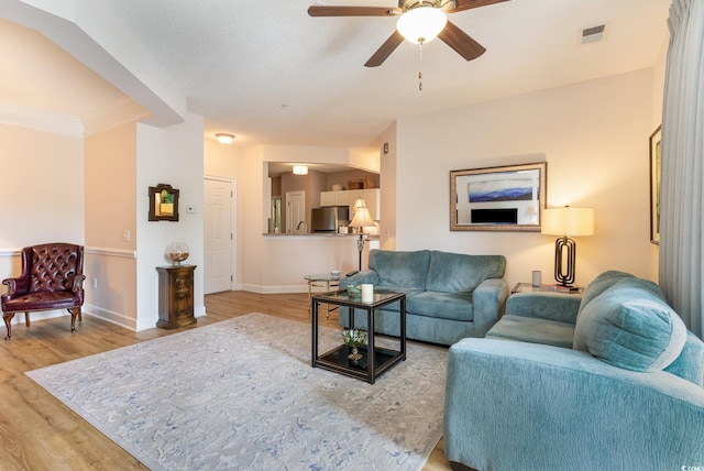 living room featuring ceiling fan and light hardwood / wood-style floors