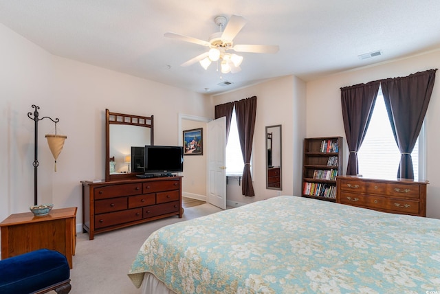 carpeted bedroom featuring ceiling fan and multiple windows