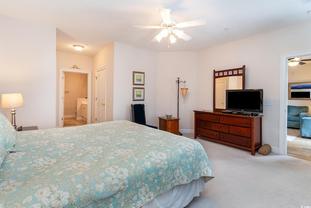 bedroom with ceiling fan, connected bathroom, a closet, and light carpet