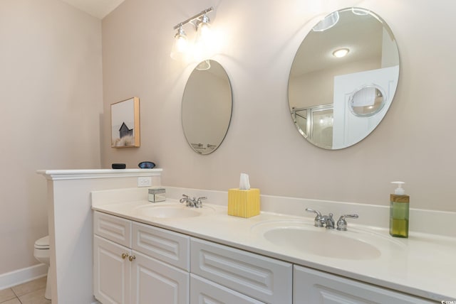 bathroom featuring toilet, a shower with door, vanity, and tile patterned floors