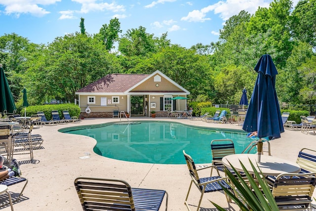 view of swimming pool with a patio area and an outbuilding