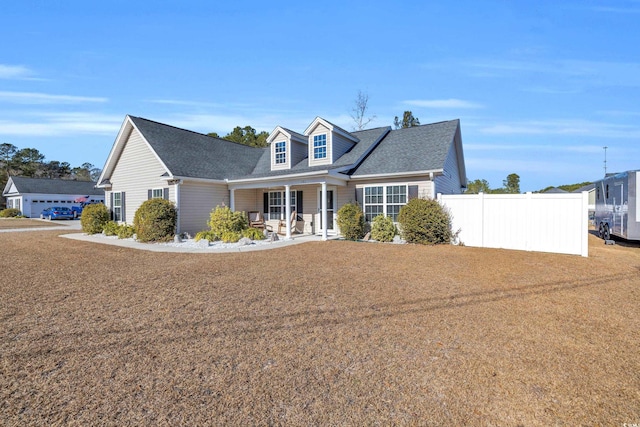 cape cod house featuring covered porch