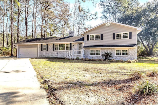 106 Governor Boone Ln, Georgetown, SC 29440 - tri-level home featuring a front lawn, a chimney, brick siding, an attached garage, and driveway