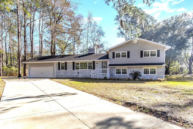 106 Governor Boone Ln, Georgetown, SC 29440 - split level home with an attached garage, a chimney, driveway, and a front yard