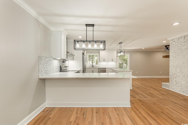 106 Governor Boone Ln, Georgetown, SC 29440 - kitchen with light wood-type flooring, backsplash, stainless steel appliances, and a peninsula