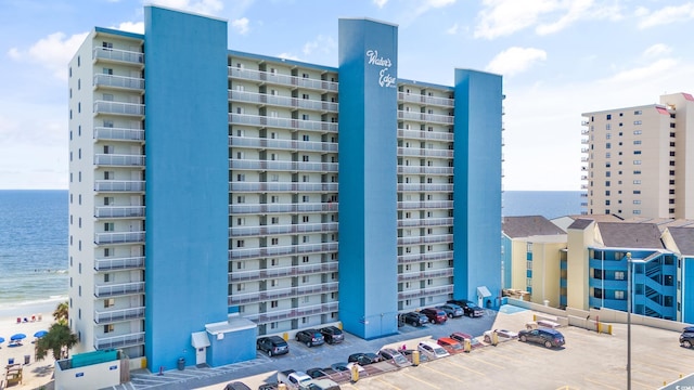view of property with uncovered parking and a water view