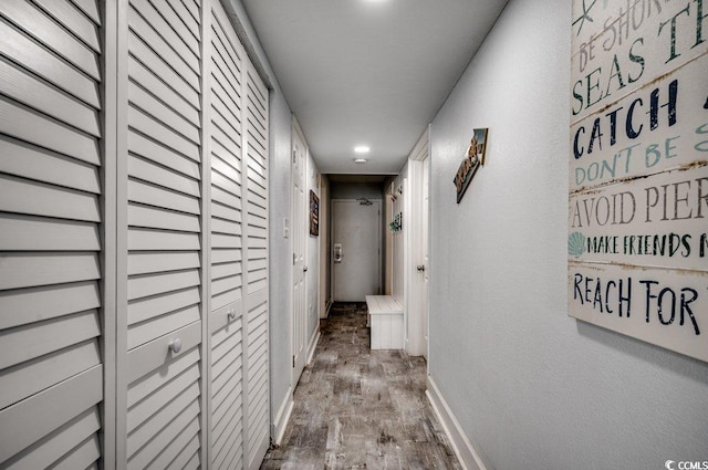 corridor with recessed lighting, wood finished floors, and baseboards