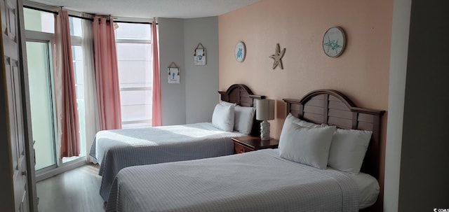 bedroom featuring expansive windows and wood-type flooring