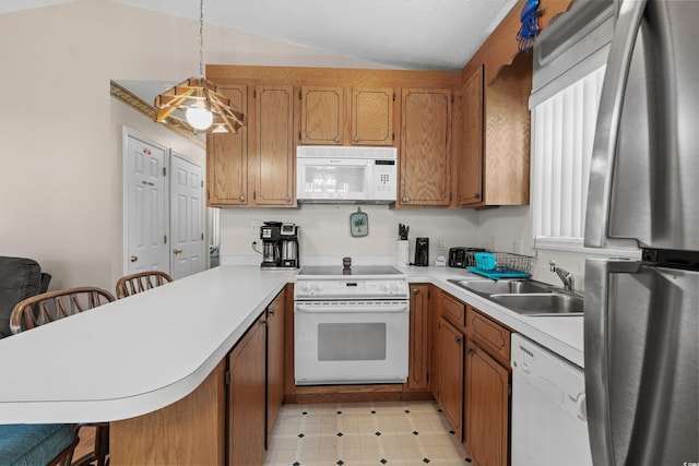 kitchen with kitchen peninsula, white appliances, a kitchen bar, and hanging light fixtures