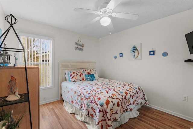 bedroom with ceiling fan and hardwood / wood-style floors