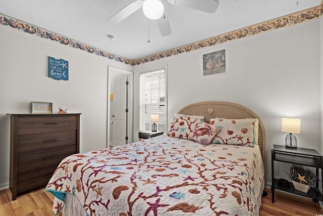 bedroom featuring ceiling fan, a textured ceiling, and light hardwood / wood-style flooring