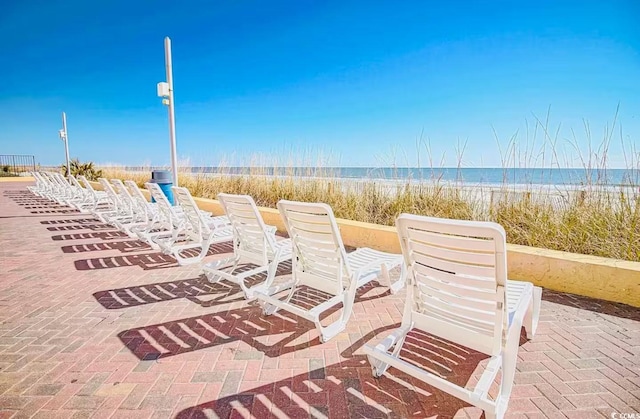 view of patio featuring a beach view and a water view