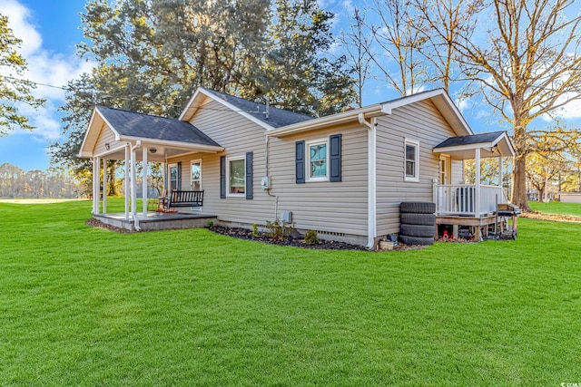 rear view of property featuring a porch and a yard