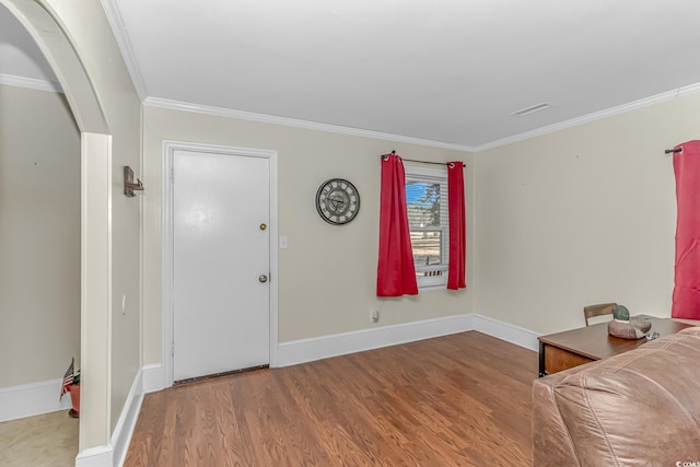 foyer entrance with ornamental molding and hardwood / wood-style flooring