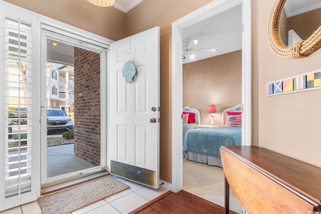 entrance foyer with ceiling fan, light tile patterned floors, and ornamental molding