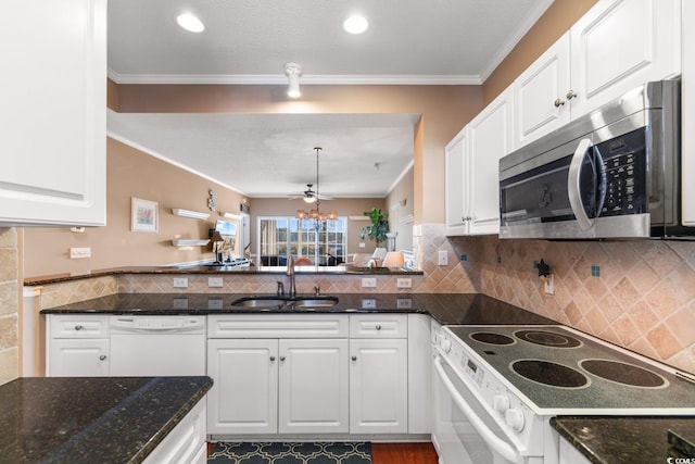 kitchen with sink, white cabinets, white appliances, dark stone counters, and crown molding