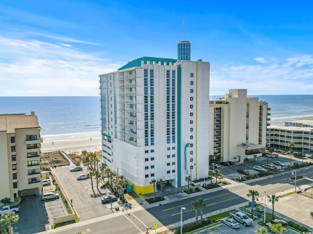 view of building exterior featuring a view of the beach and a water view