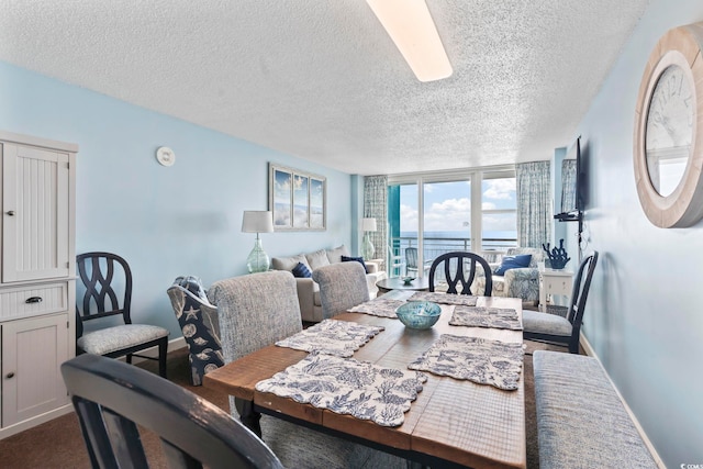 dining area featuring a textured ceiling and a wall of windows