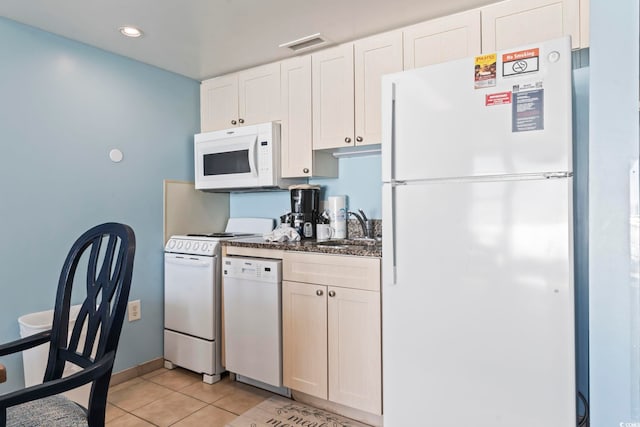 kitchen featuring light tile patterned floors, sink, white cabinets, and white appliances