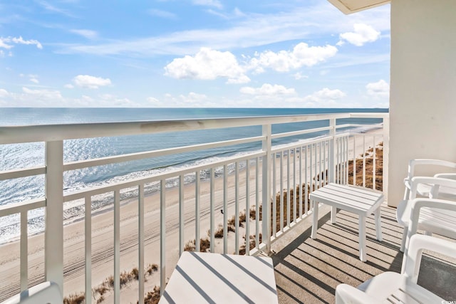 balcony featuring a beach view and a water view