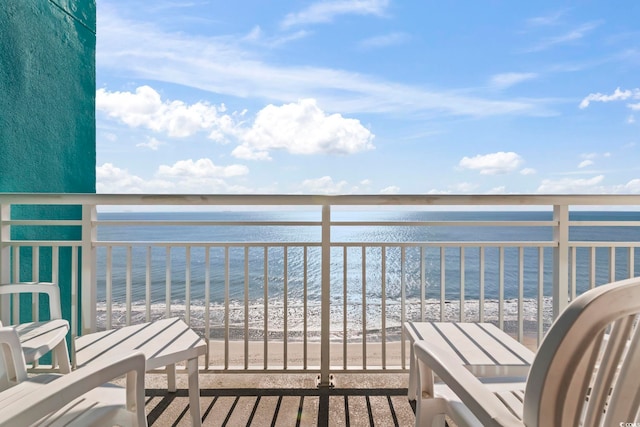 balcony featuring a view of the beach and a water view