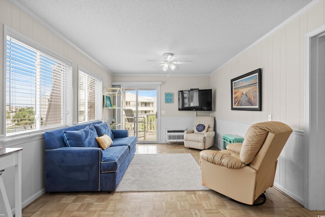 living room with ornamental molding, light parquet flooring, and a textured ceiling