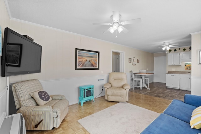 living room with ceiling fan, crown molding, and light parquet flooring