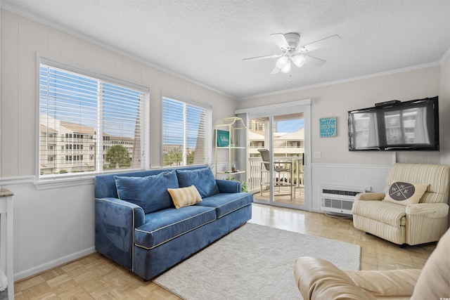 living room with ceiling fan, ornamental molding, a textured ceiling, and light parquet floors