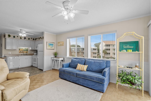 living room featuring light parquet flooring, sink, ceiling fan, and a textured ceiling