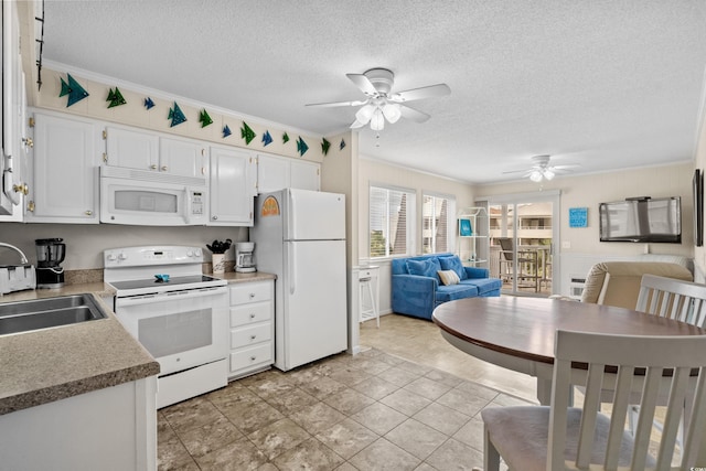 kitchen with sink, a textured ceiling, ornamental molding, white appliances, and white cabinets