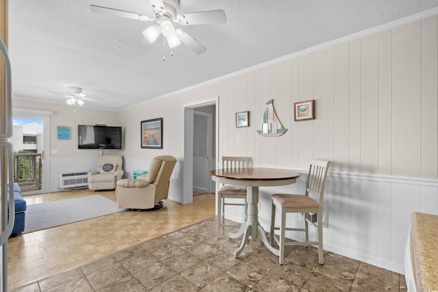 dining area featuring heating unit, parquet flooring, ornamental molding, and a textured ceiling