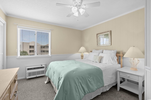 bedroom featuring crown molding, ceiling fan, carpet, a textured ceiling, and an AC wall unit