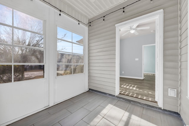 unfurnished sunroom with ceiling fan