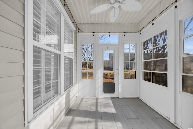 unfurnished sunroom featuring ceiling fan