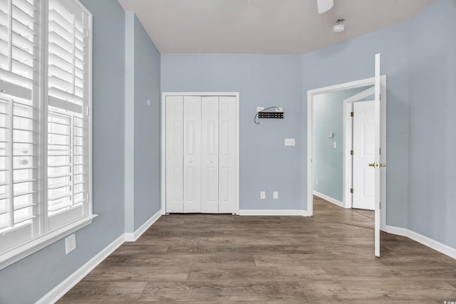 unfurnished bedroom with a closet and hardwood / wood-style flooring