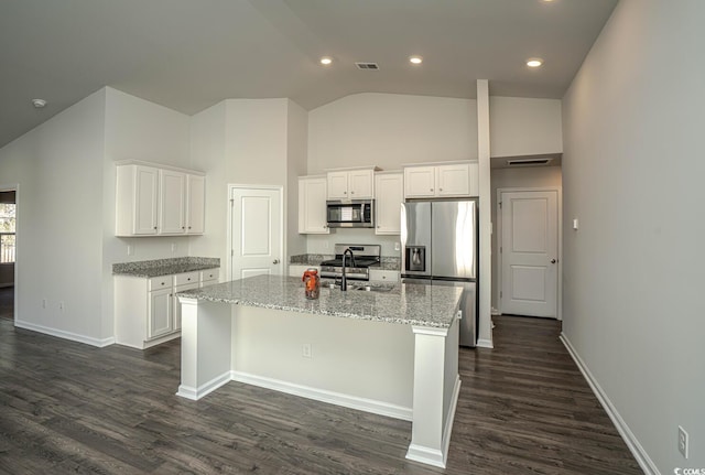 kitchen featuring appliances with stainless steel finishes, white cabinets, a center island with sink, and sink