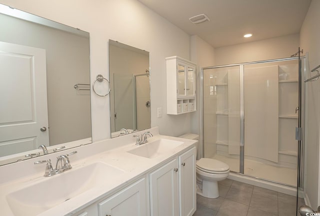 bathroom with a shower with shower door, vanity, tile patterned flooring, and toilet