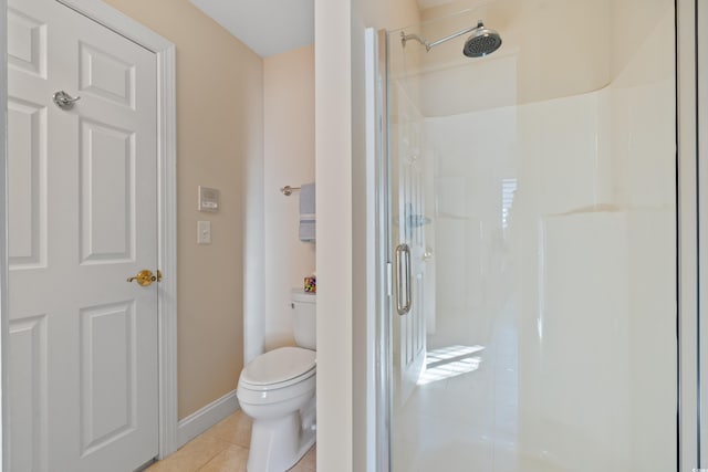 bathroom featuring a shower with door, tile patterned flooring, and toilet