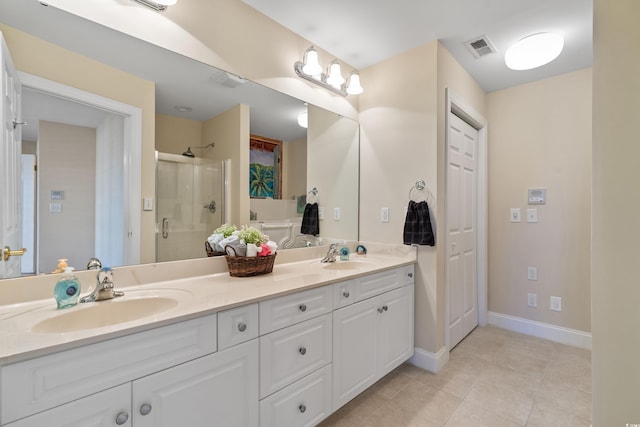 bathroom featuring a shower with door, tile patterned floors, and vanity