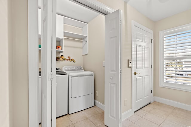 laundry area with separate washer and dryer and light tile patterned floors