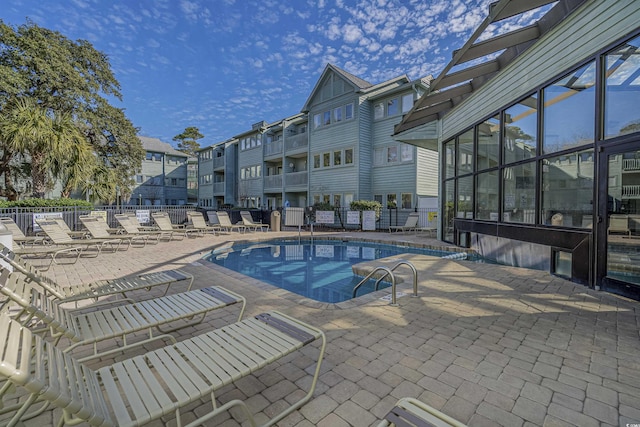 community pool featuring a patio and fence