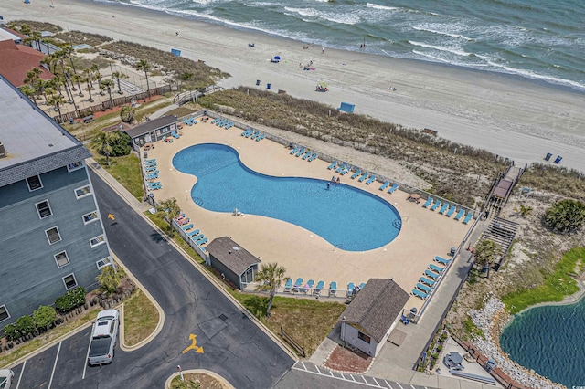 bird's eye view of waterfront with a beach and a pool area