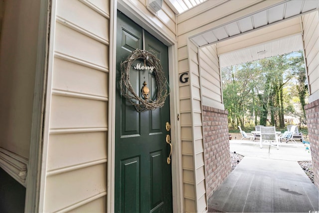 view of exterior entry featuring a patio area