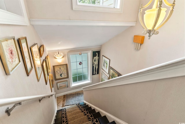 stairs featuring a chandelier, a healthy amount of sunlight, and tile patterned floors