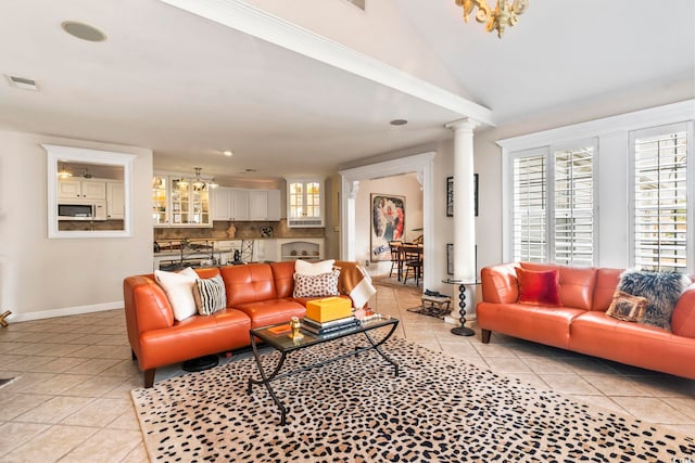 living room featuring decorative columns, light tile patterned floors, and vaulted ceiling